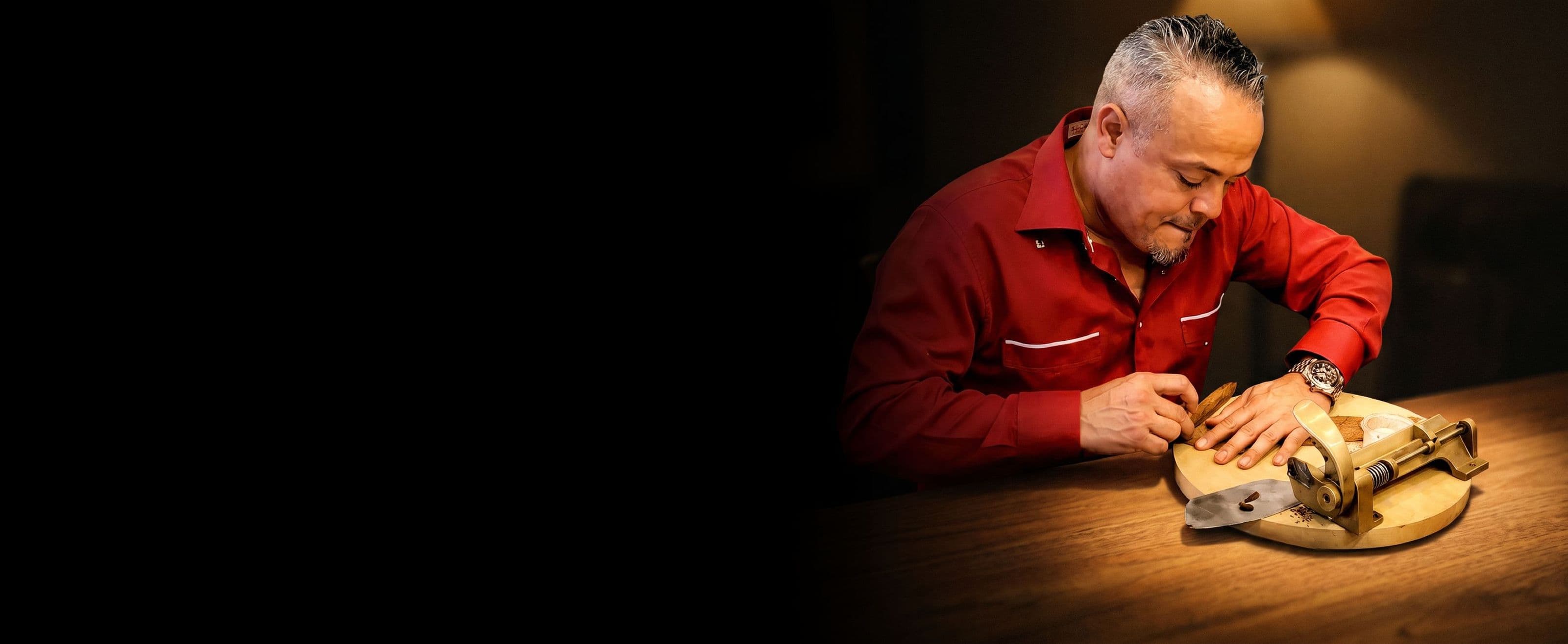 A master roller’s hands finishing a cigar on the table