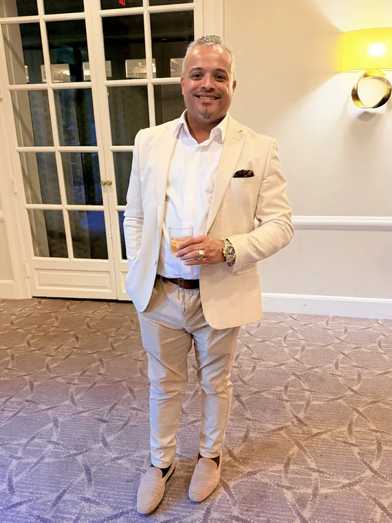 Franklin Pichardo in a cream suit, looking at the camera