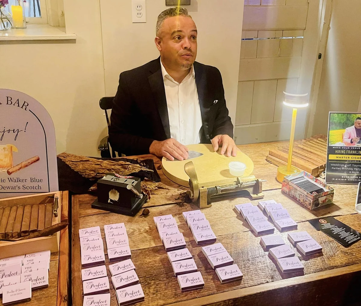 Franklin rolling at the long table, the finished cigars already lined up
